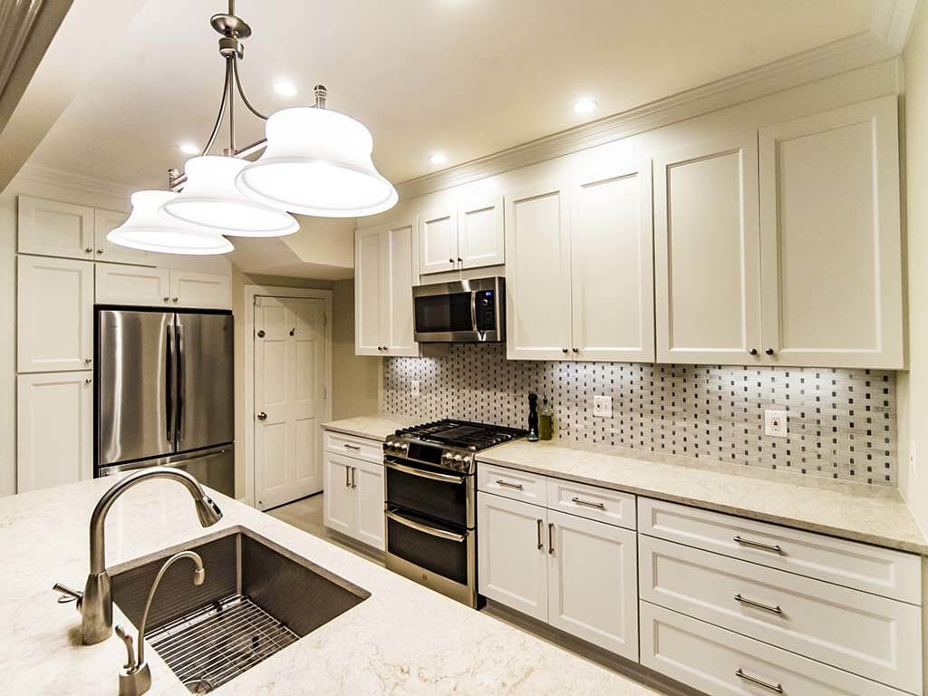 Light, elegant kitchen style with white shaker cabinets and cream color countertop