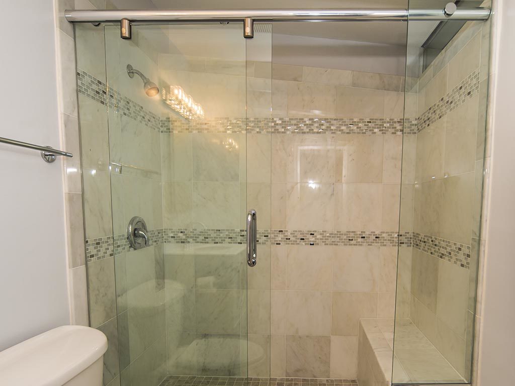 Shower with glass sliding door, and a toilet