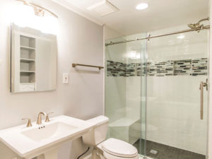 Clean, relaxing bathroom with vanity, toilet, and a shower