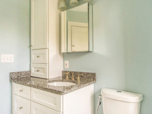 Light green bathroom with vanity, and toilet