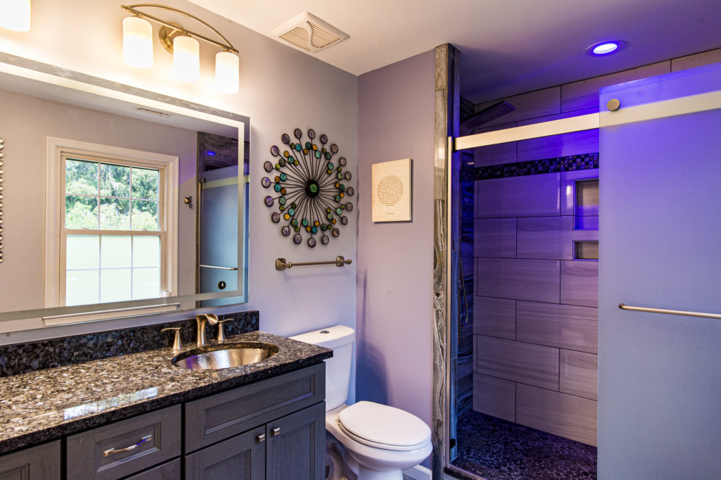 Elegant bathroom style with vanity, toilet and a shower with dark lighting