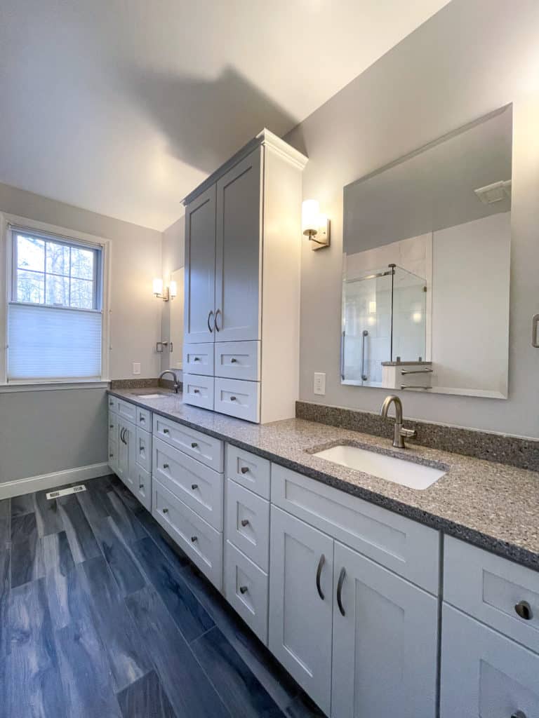 Long bathroom cabinets with wood flooring and white cabinet doors