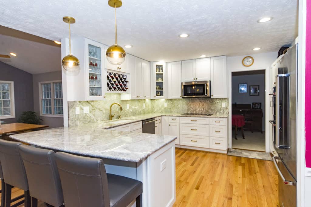 Elegant kitchen project with white shaker cabinets and granite countertop and backsplash