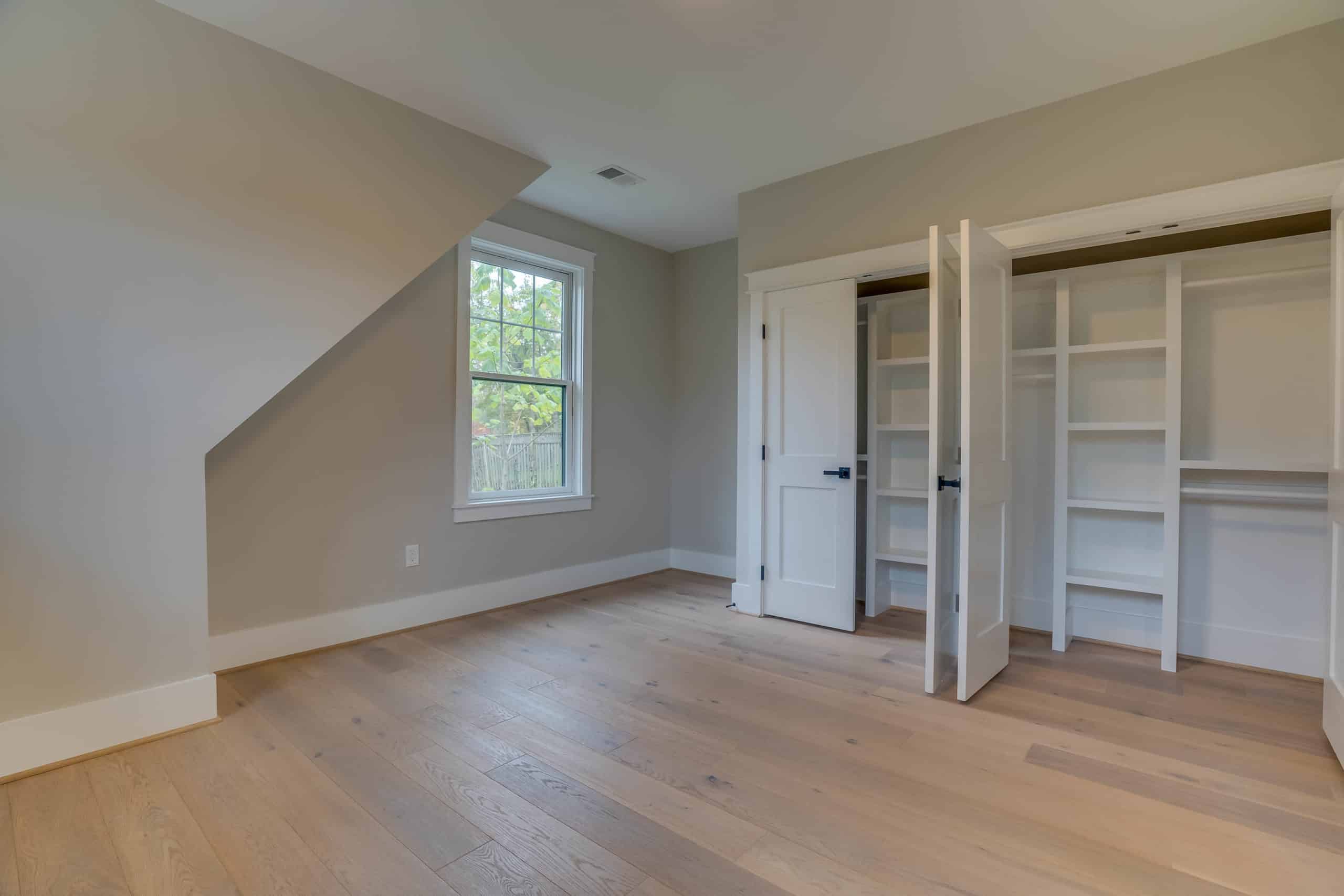 Beige room with closet and wood flooring