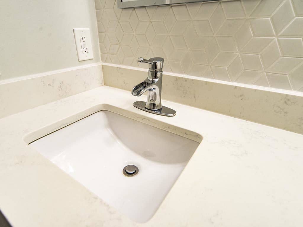 White countertop with undermount sink and silver chrome