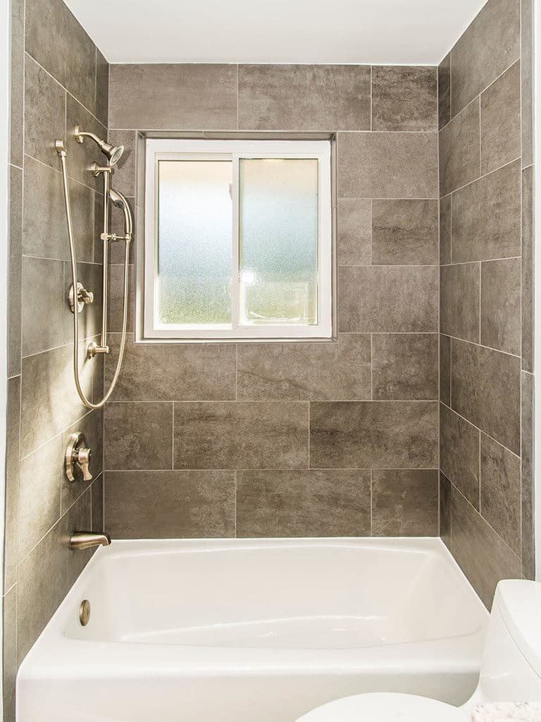 Tub-shower combination with brown surround tiles