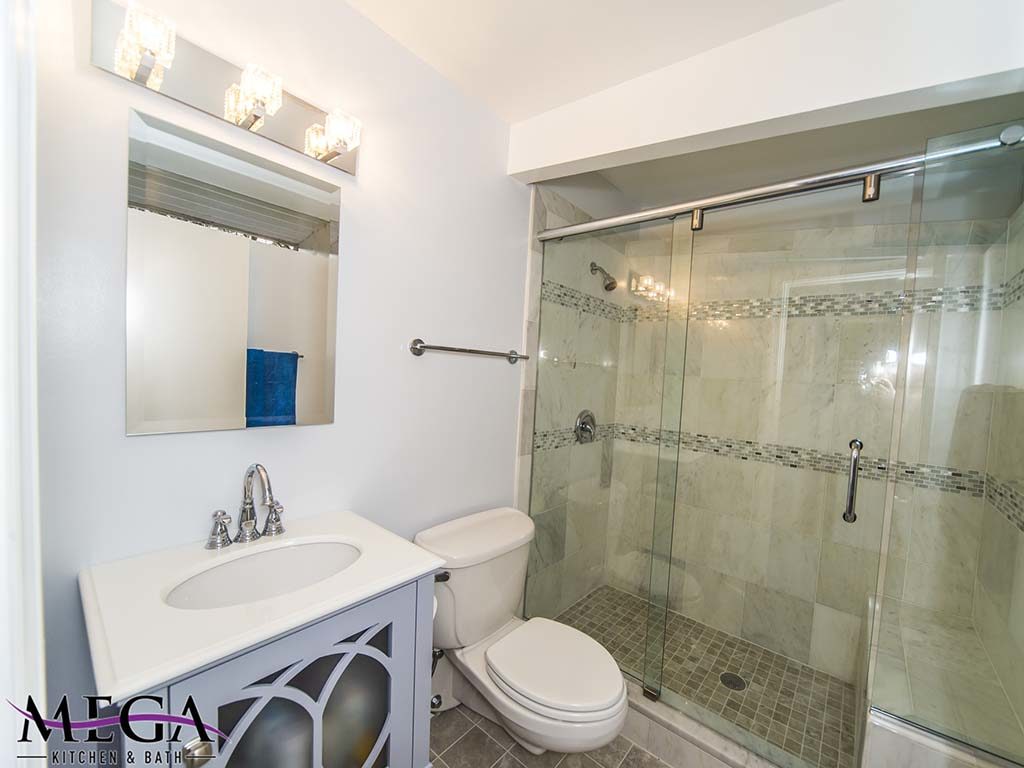 Shower with glass sliding door, vanity, and a toilet