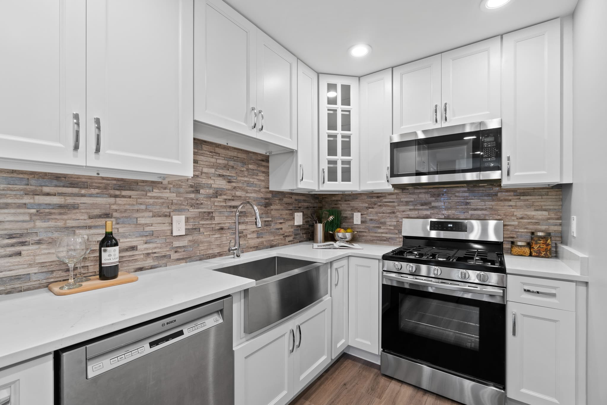 Elegant kitchen with white shaker cabinets, and brownish backsplash