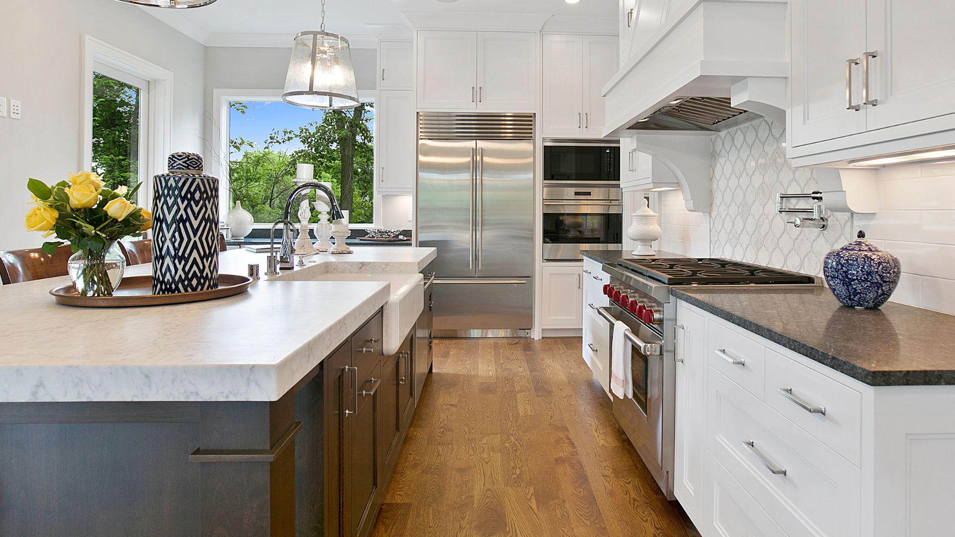 Luxury, farmhouse style kitchen with white shaker cabinets, and white island top