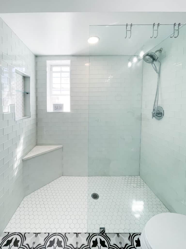 Spacious white shower with glass door