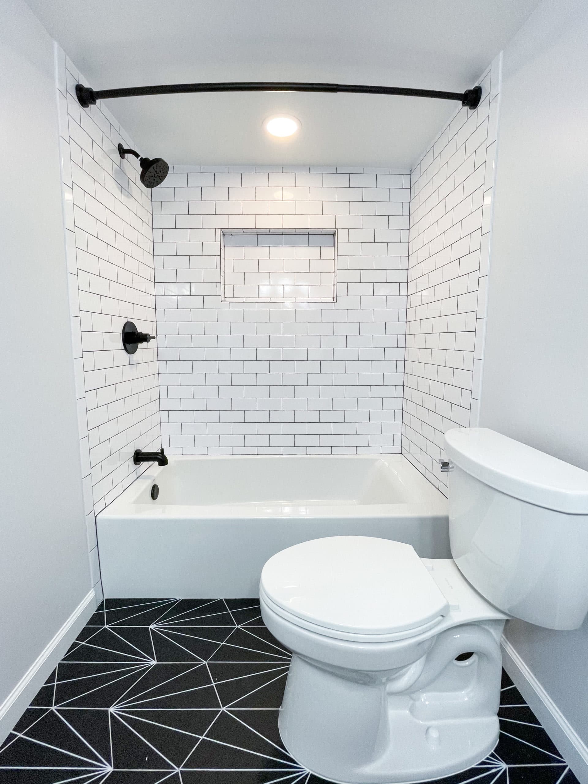Bathroom with tub-shower combination, and a toilet