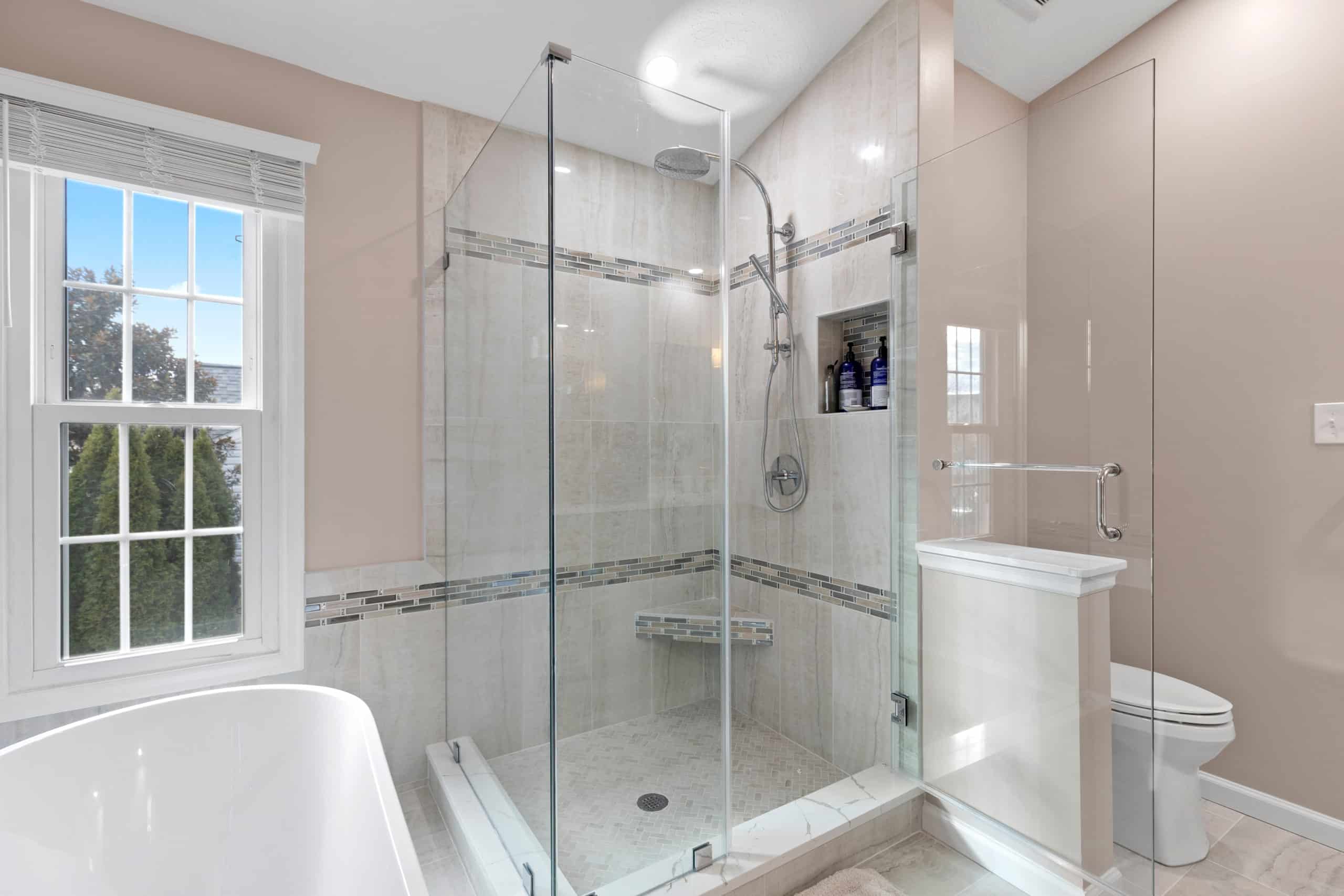 Light pink bathroom with elegant walk-in shower, tub, and toilet