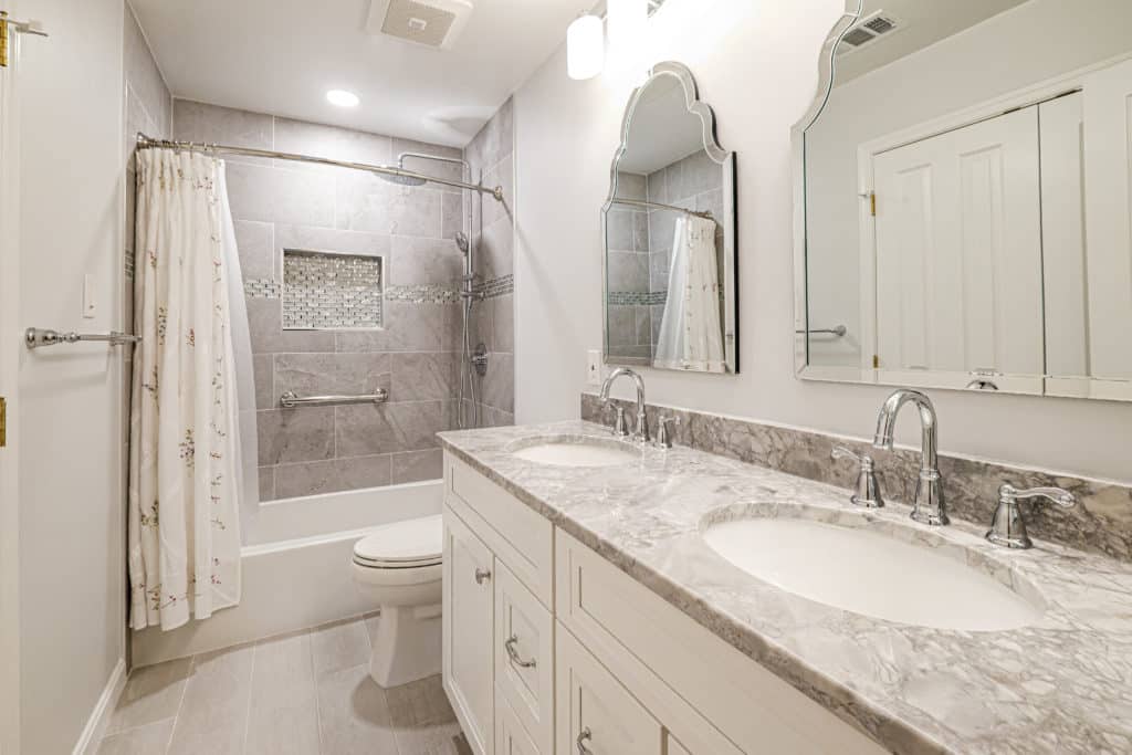 Cream bathroom style with double sink vanity, toilet and a shower-tub combination