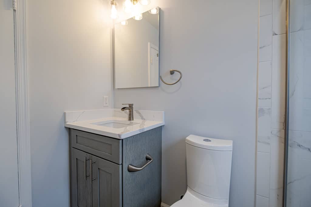 Bathroom with dark gray single vanity and a toilet