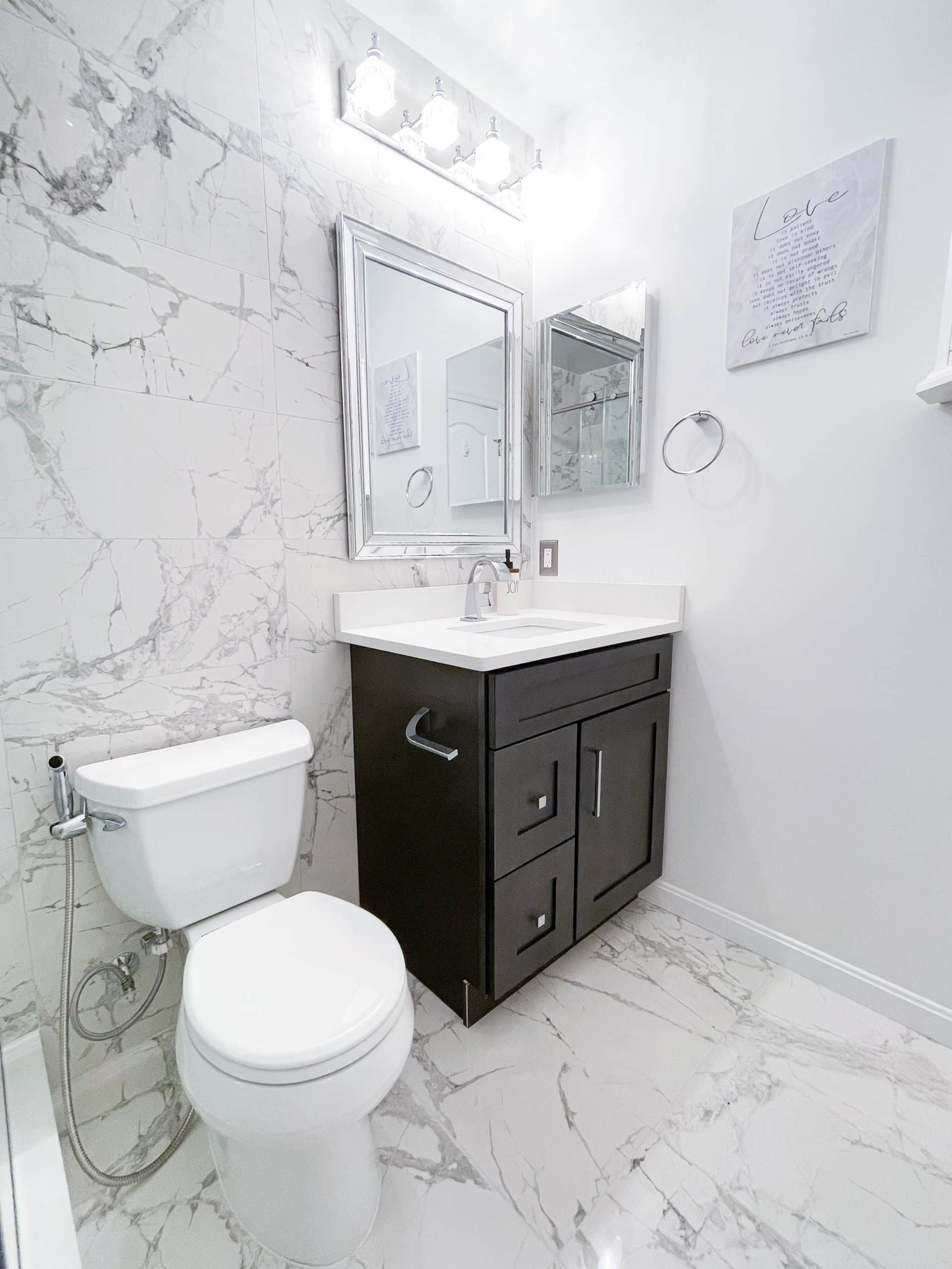 White bathroom style with brown vanity, and a toilet
