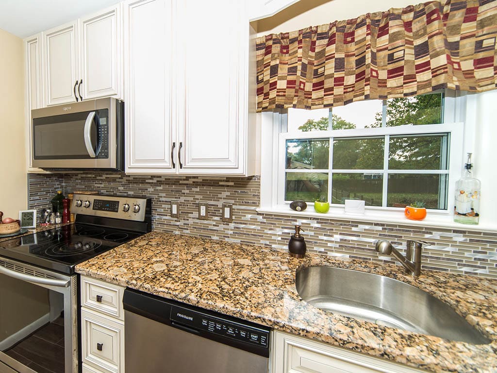 Cream, L style kitchen with traditional cabinets and granite countertop