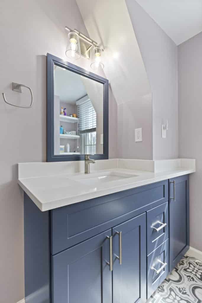 Small bathroom with navy blue vanity with white countertop