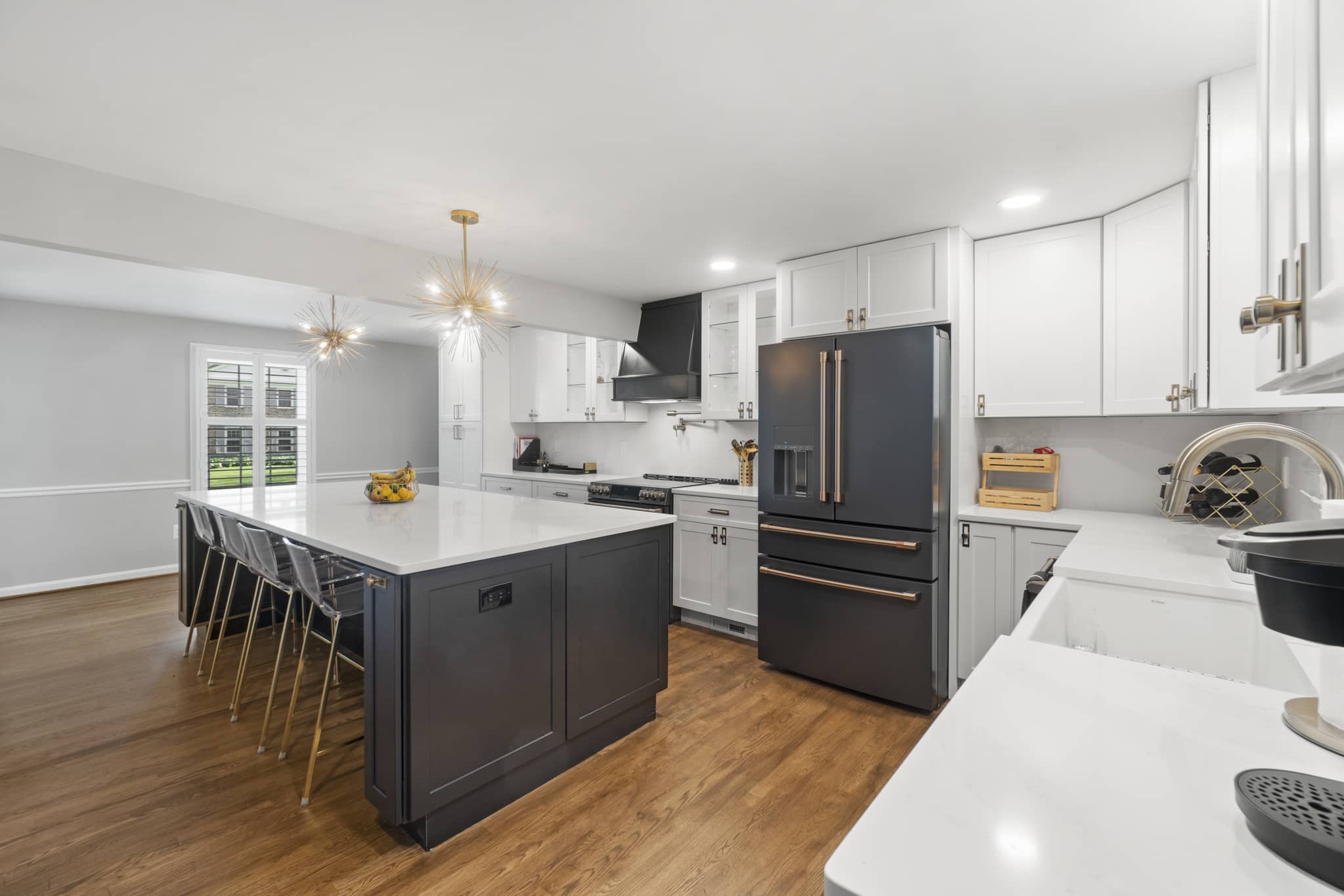 Elegant kitchen design with white shaker cabinets, white countertop, and gray kitchen island