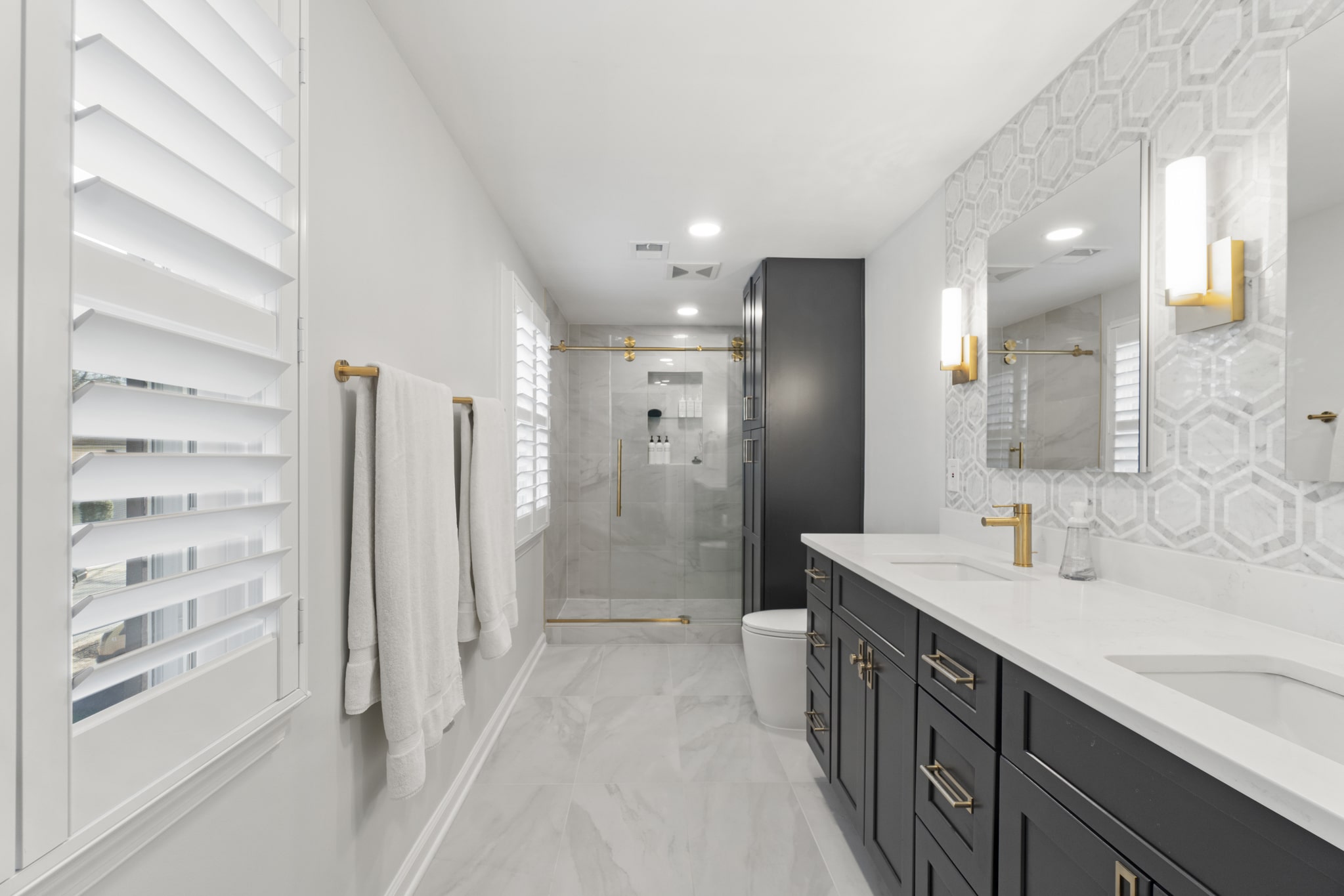 Luxury bathroom style with dark gray shaker cabinets, white countertop, toilet, and a shower