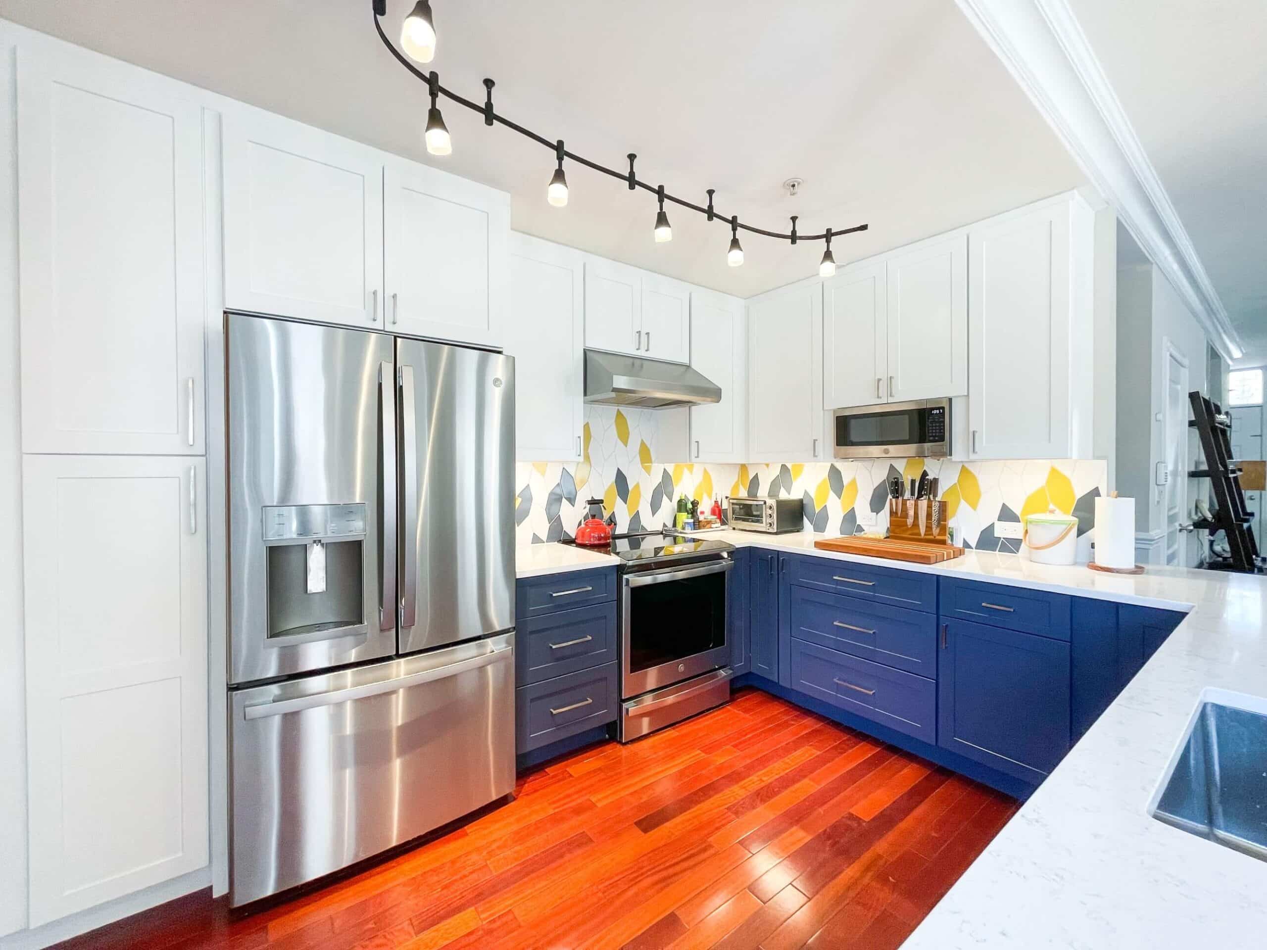 Fancy kitchen design with white and navy blue cabinets, and wood flooring
