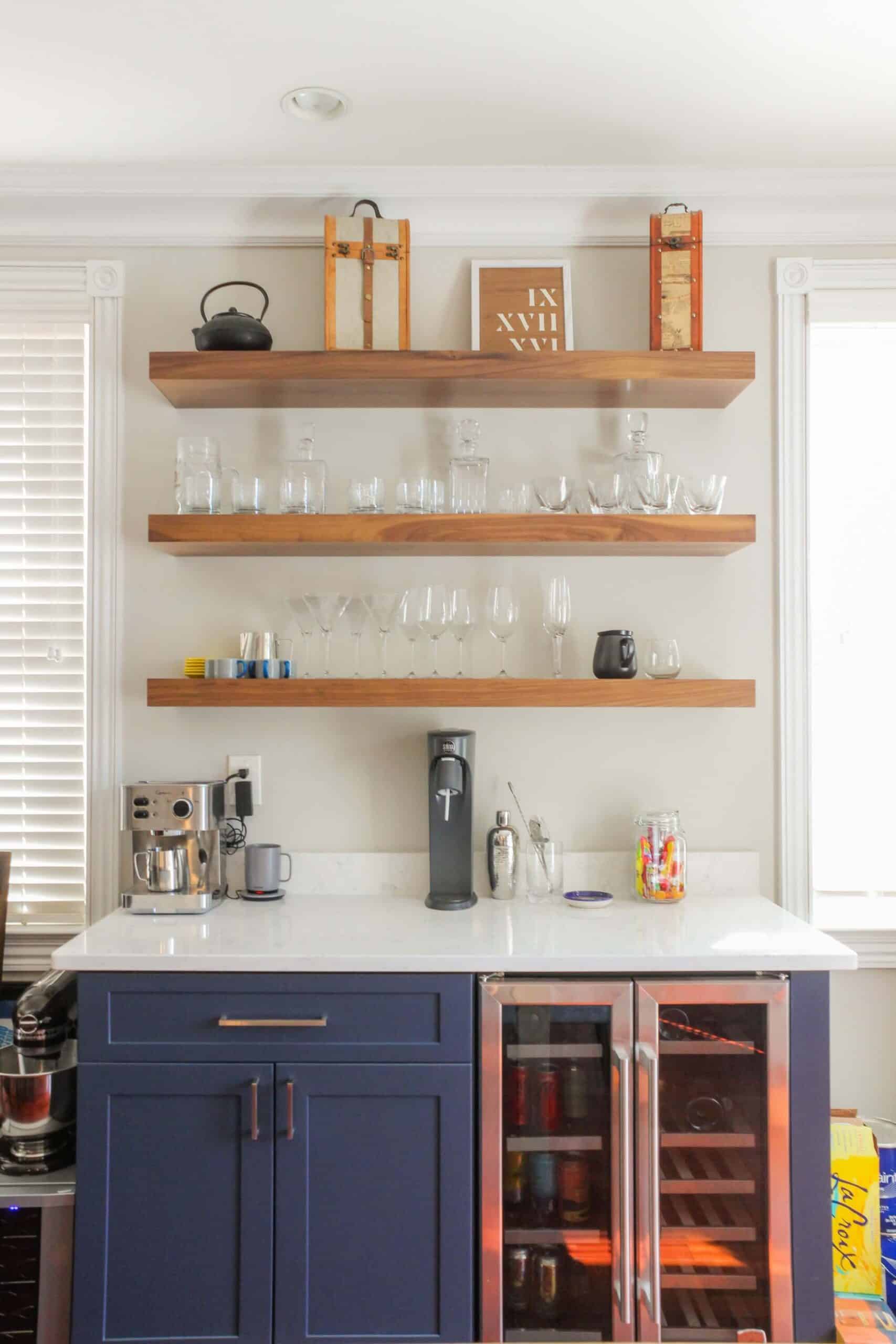 Fancy kitchen design with open shelf and navy blue cabinets, and wood flooring