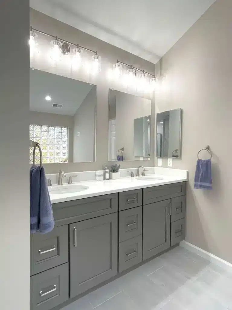 Dark gray double sink vanity with mirrors and lighting