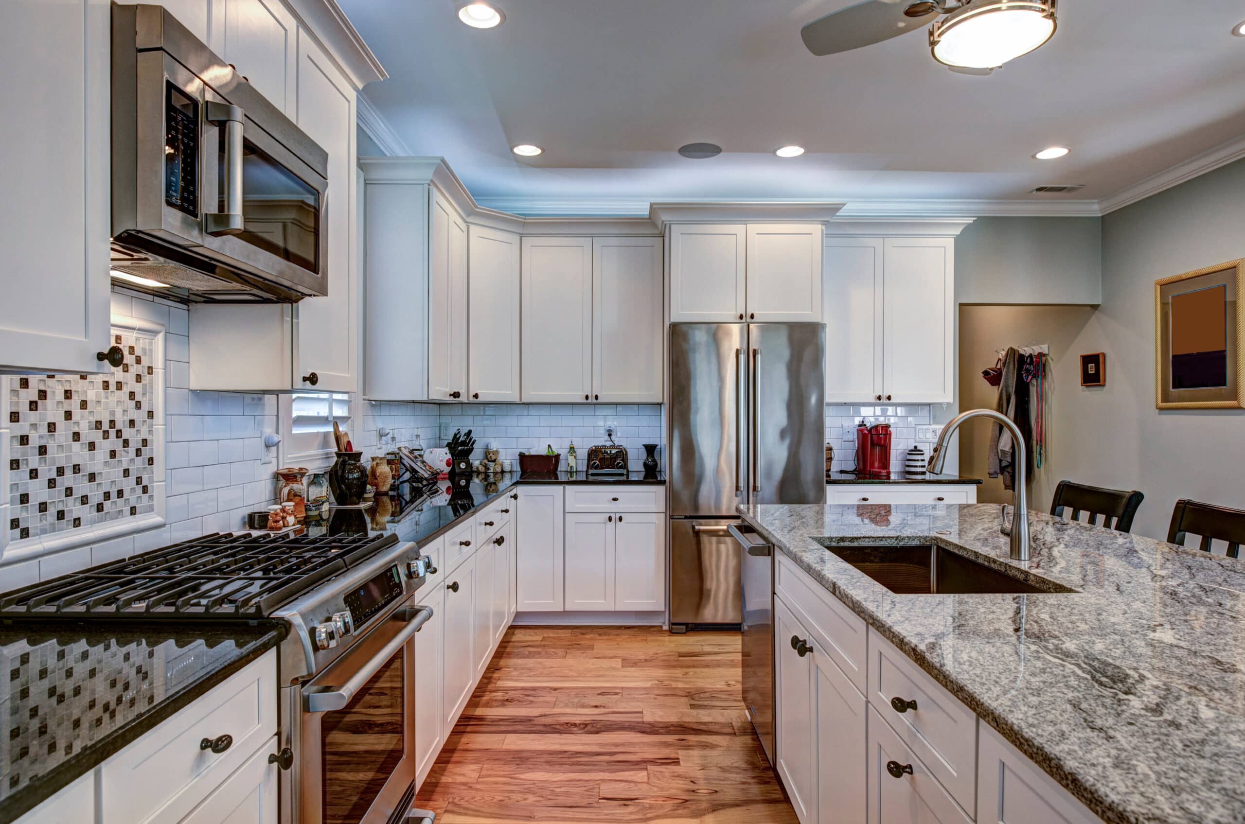 High-end luxury kitchen with granite countertops and white cabinets.