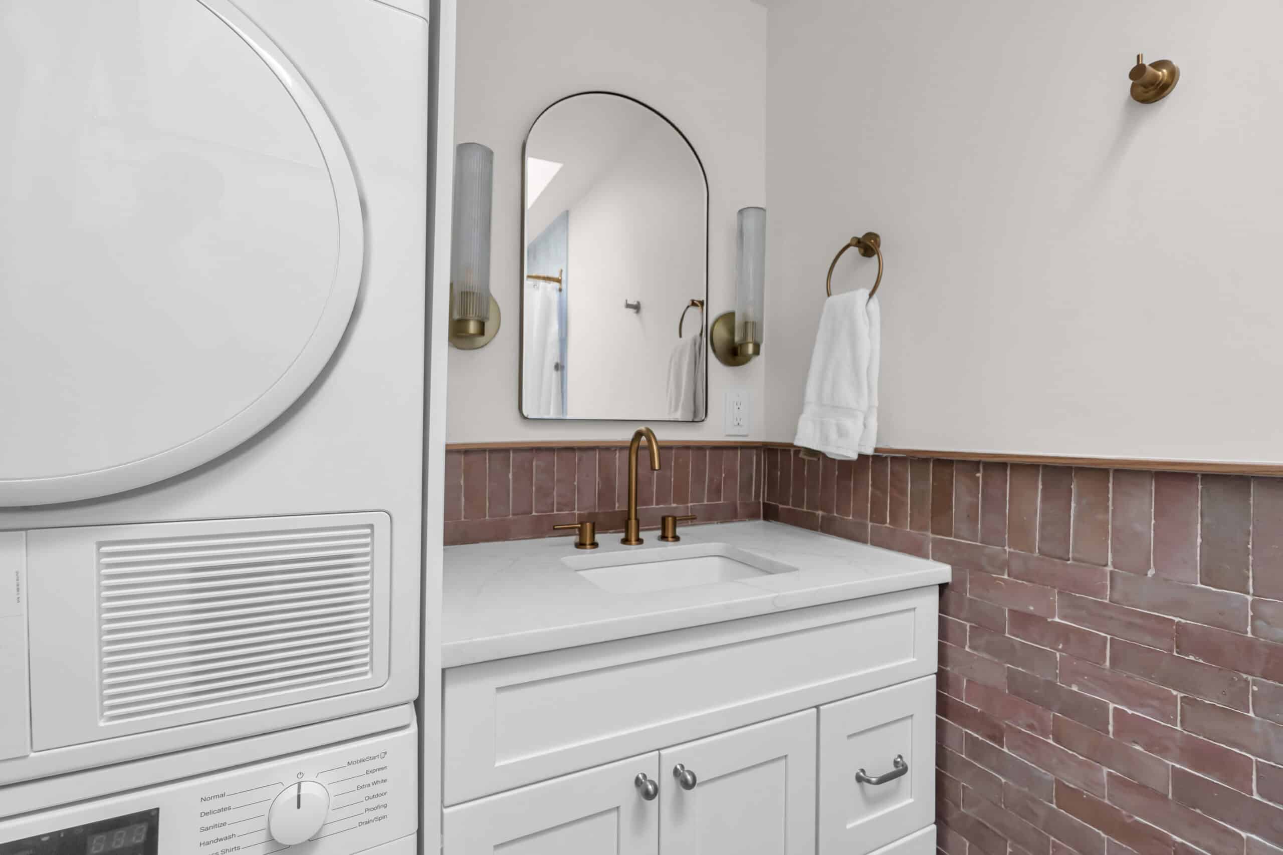 White bathroom vanity with brown tile surround