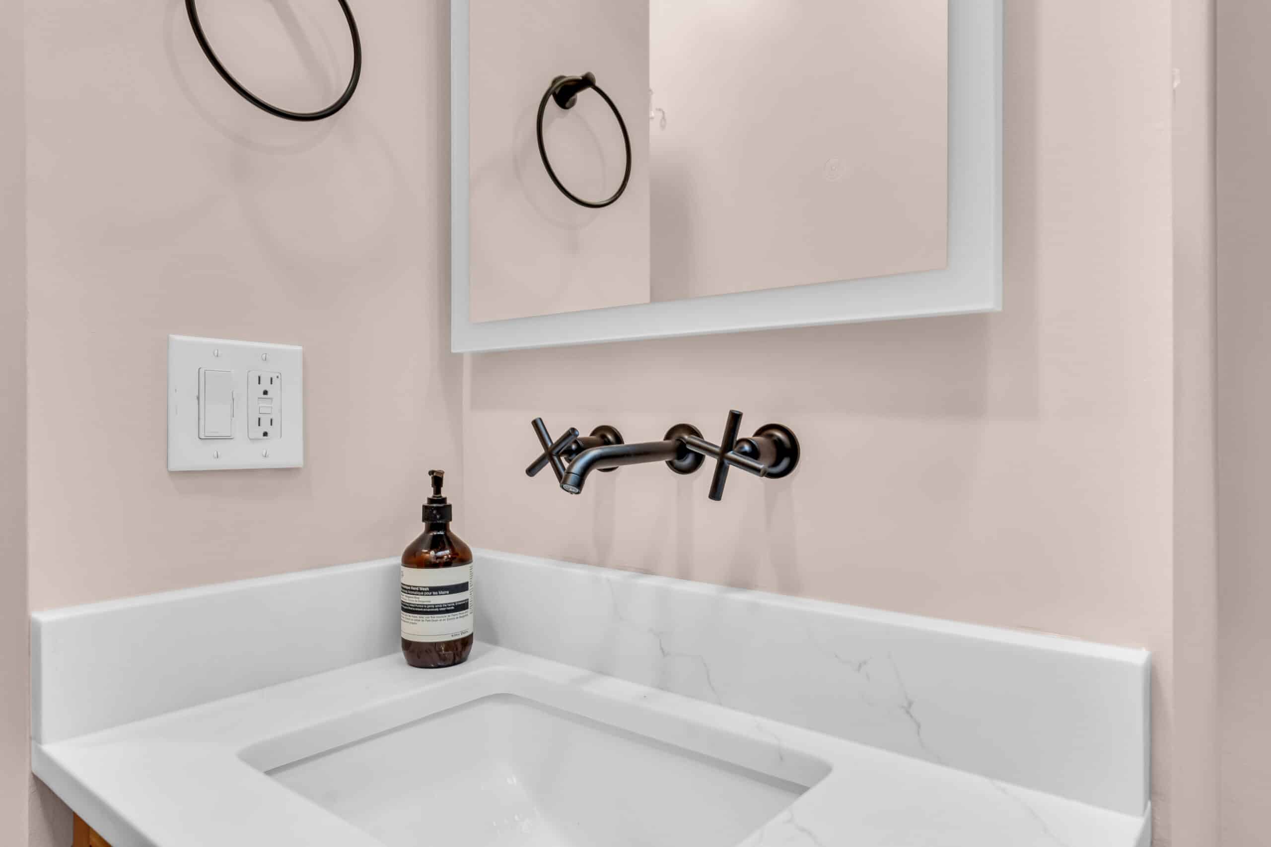 Beige bathroom with white countertop, black hardware