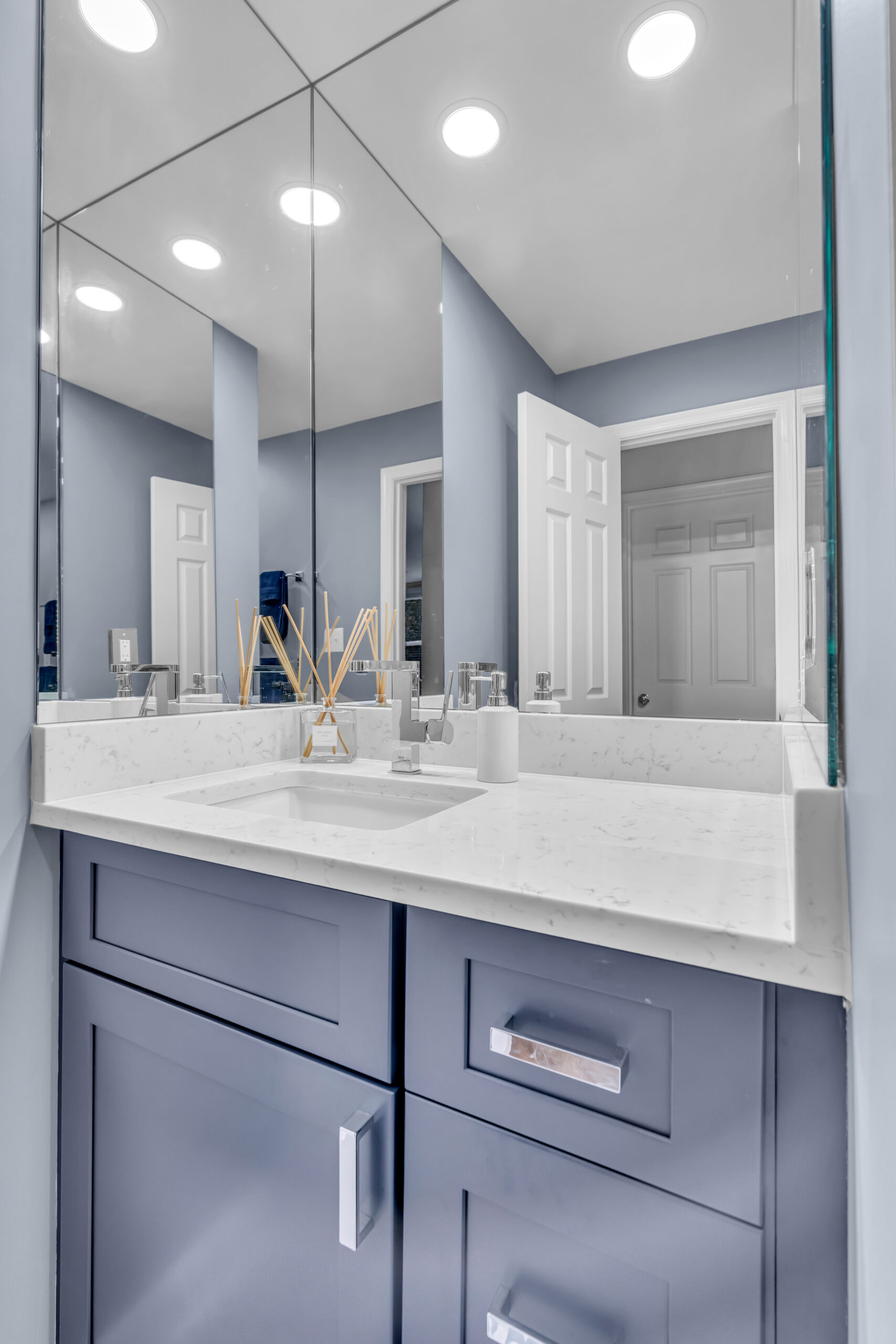 Grey bathroom design with navy blue shaker vanity,