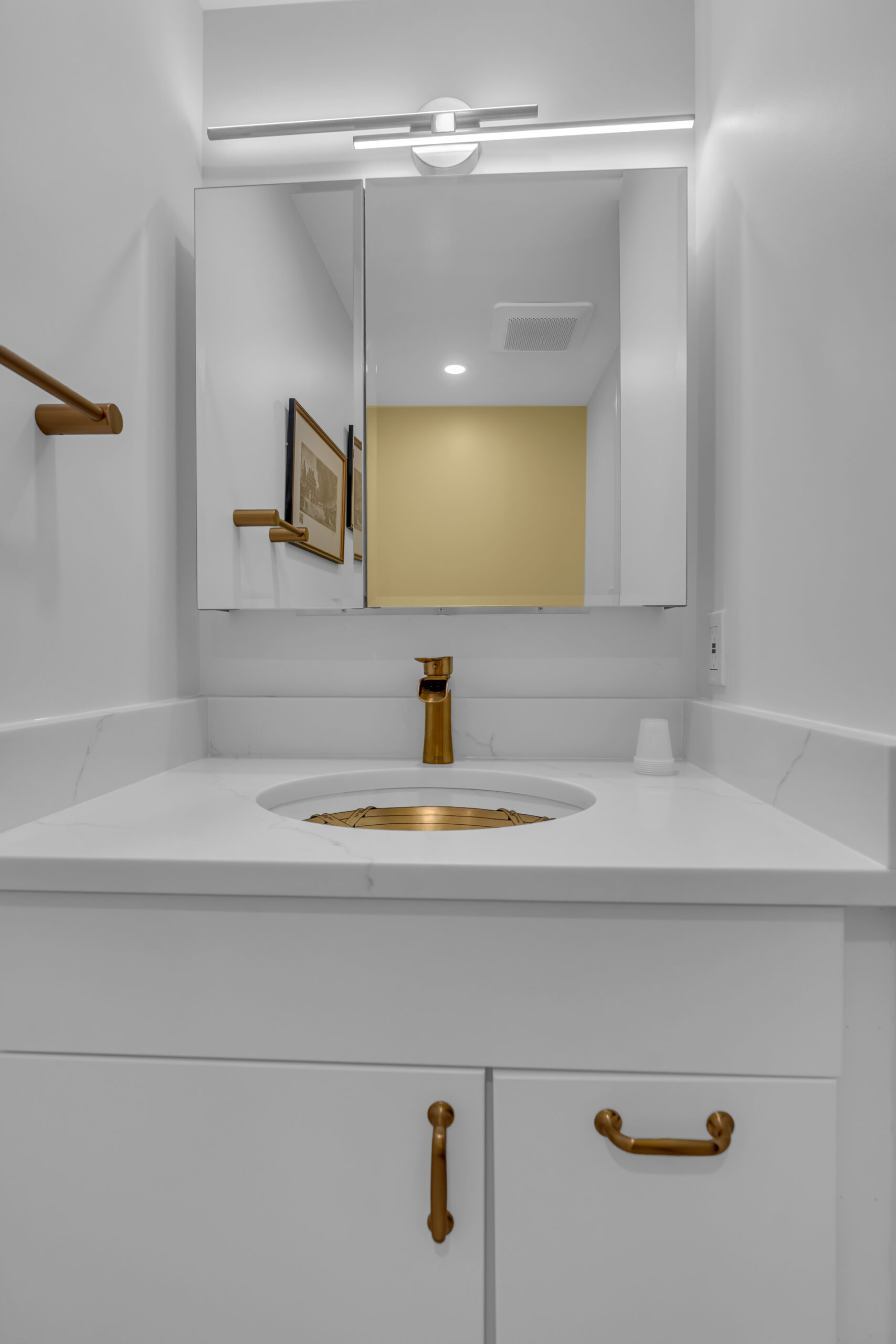 White vanity with gold sink and faucet