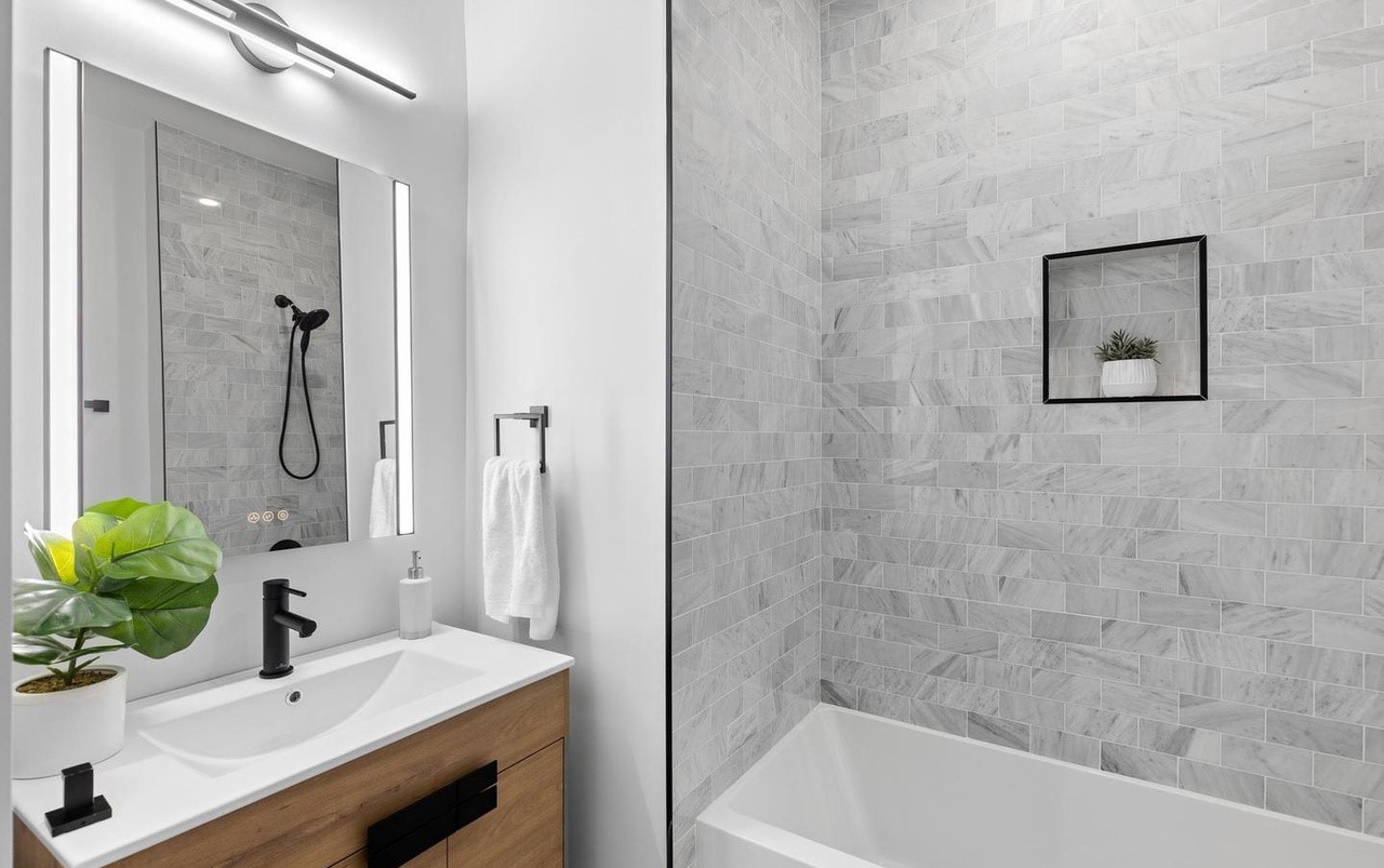 Elegant bathroom with brown vanity, and tub in DC