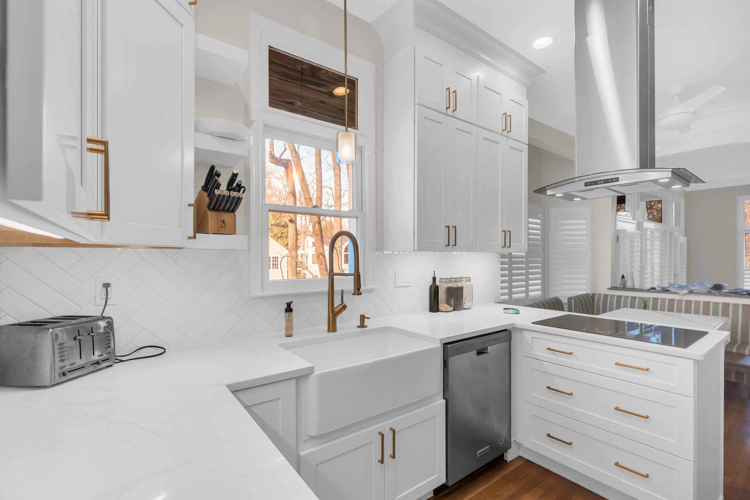White kitchen design with shaker cabinets and wood flooring