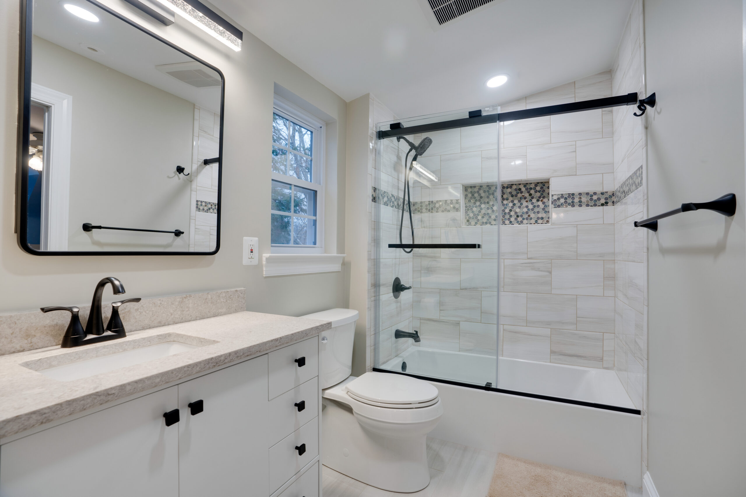 white bathroom with vanity, toilet, and tub-shower combination