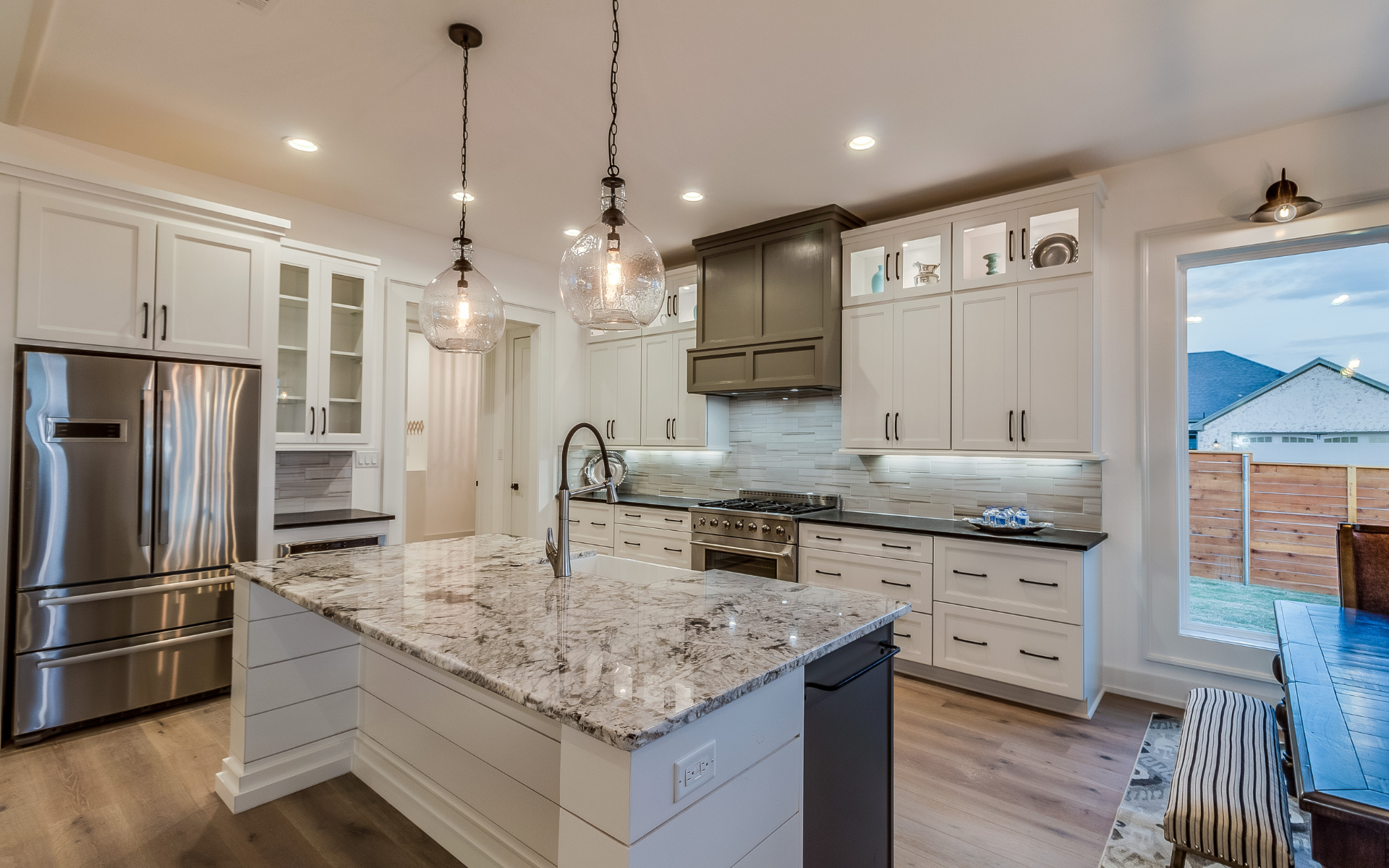 Elegant kitchen with white cabinets, kitchen island, and granite countertops