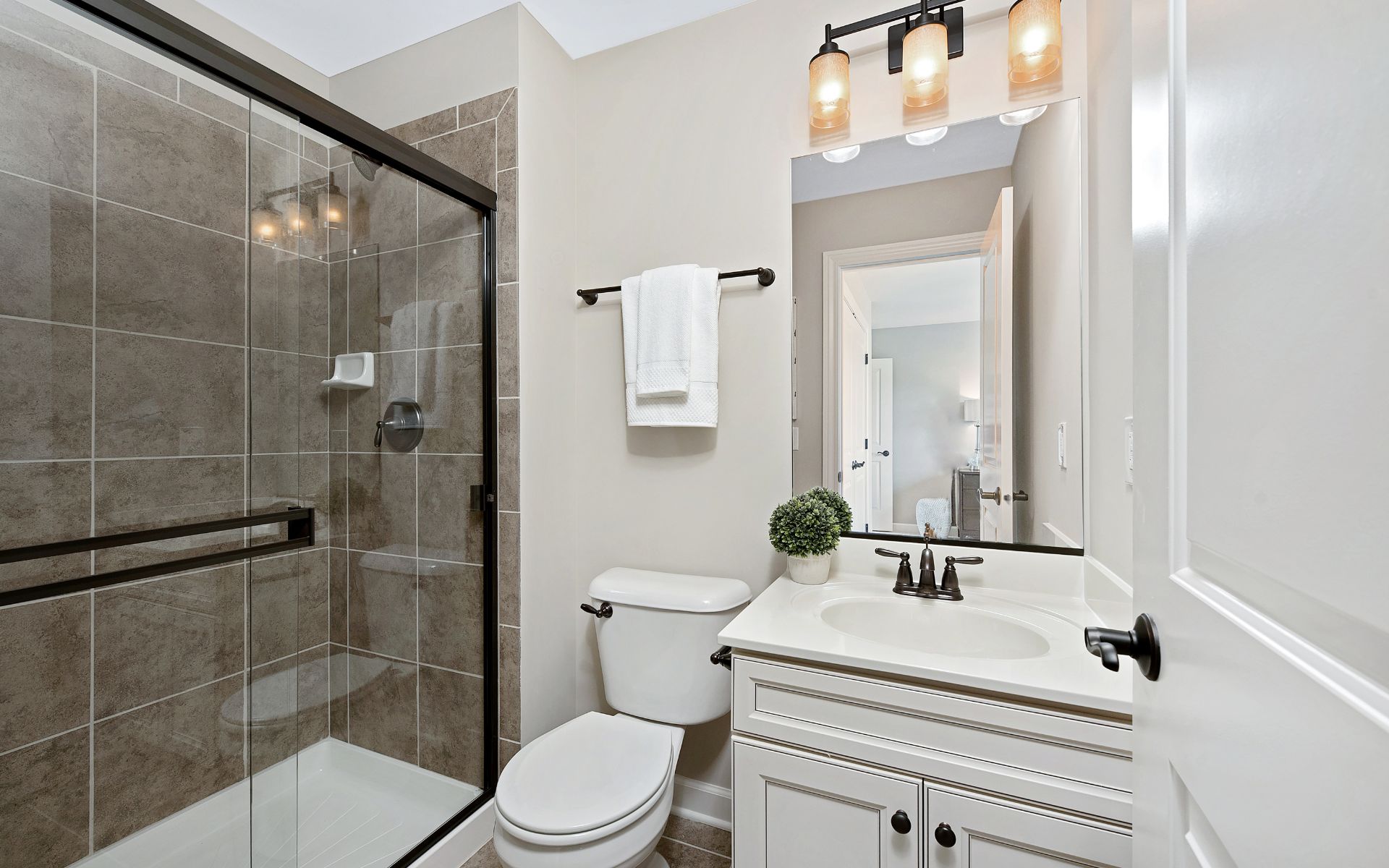 Elegant bathroom with white cabinets, toilet, and shower