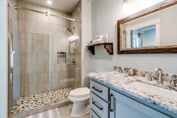 Luxurious bathroom with glass shower door, vanity, and toilet.